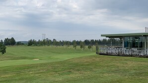A golf course with a clubhouse and a cloudy sky. - Stuga på Nässjö Golfklubb (Nassjo)