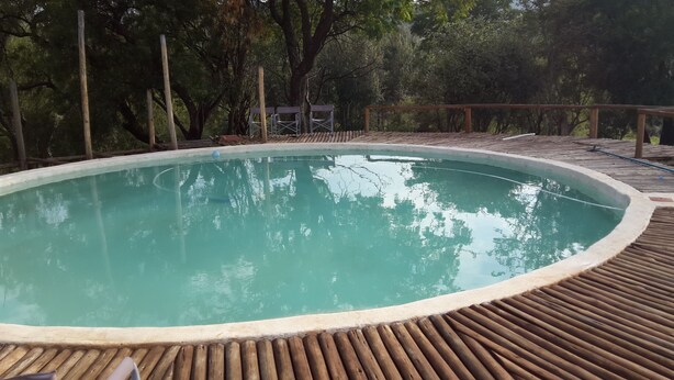 Une piscine extérieure entourée d’une terrasse en bois.