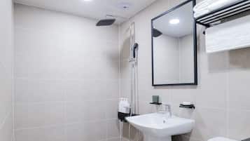Une salle de bain moderne équipée de toilettes, d’un lavabo et d’une douche.