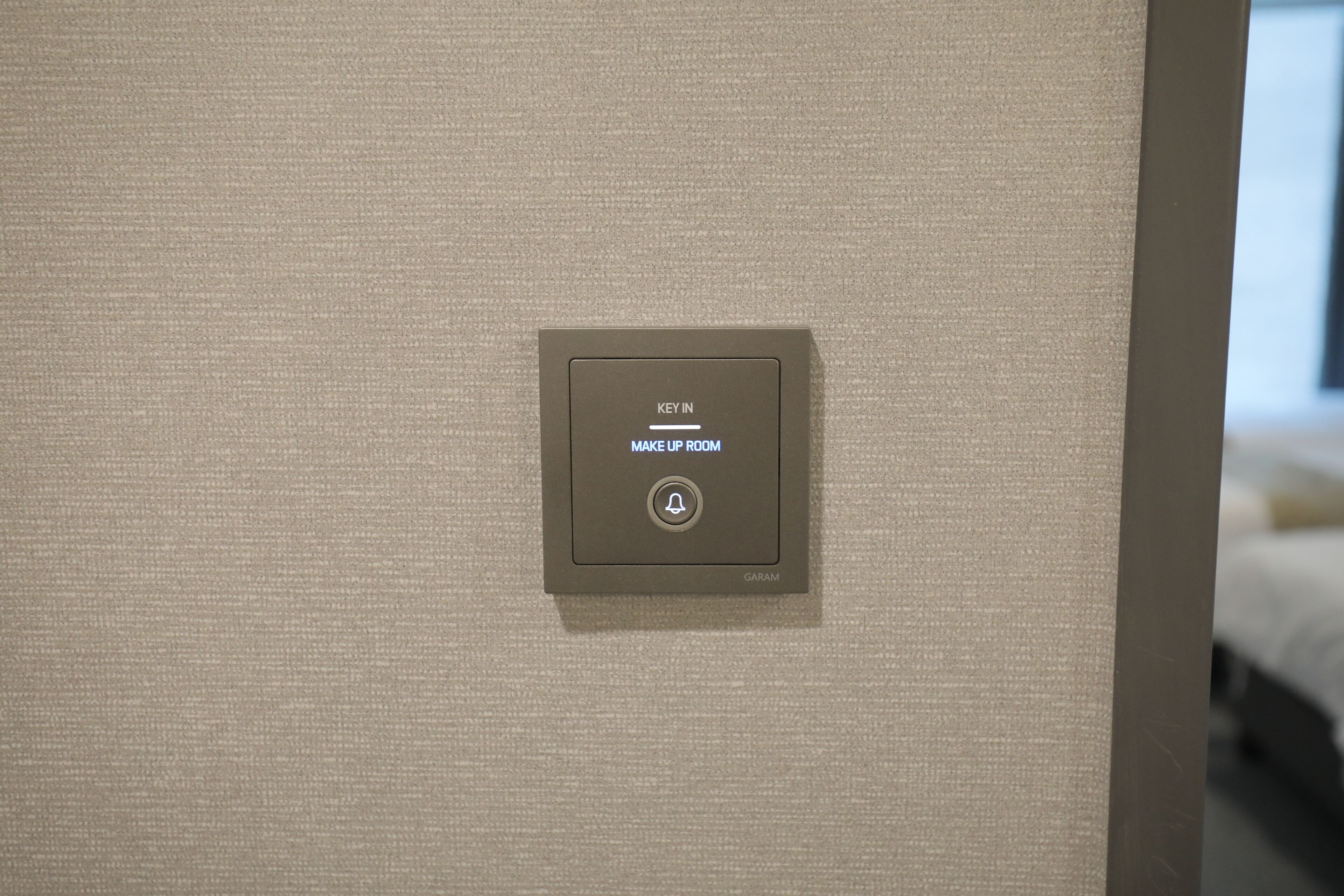 A key-in device labeled "KEY IN MAKE UP ROOM" on a textured wall.