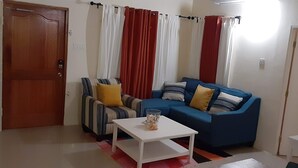 Un salon avec un canapé, un fauteuil et une table basse.