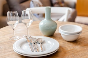 A dining table with a plate, cutlery, and a vase. - Sitio dos Cavaleiros Apartments (Lisbon)