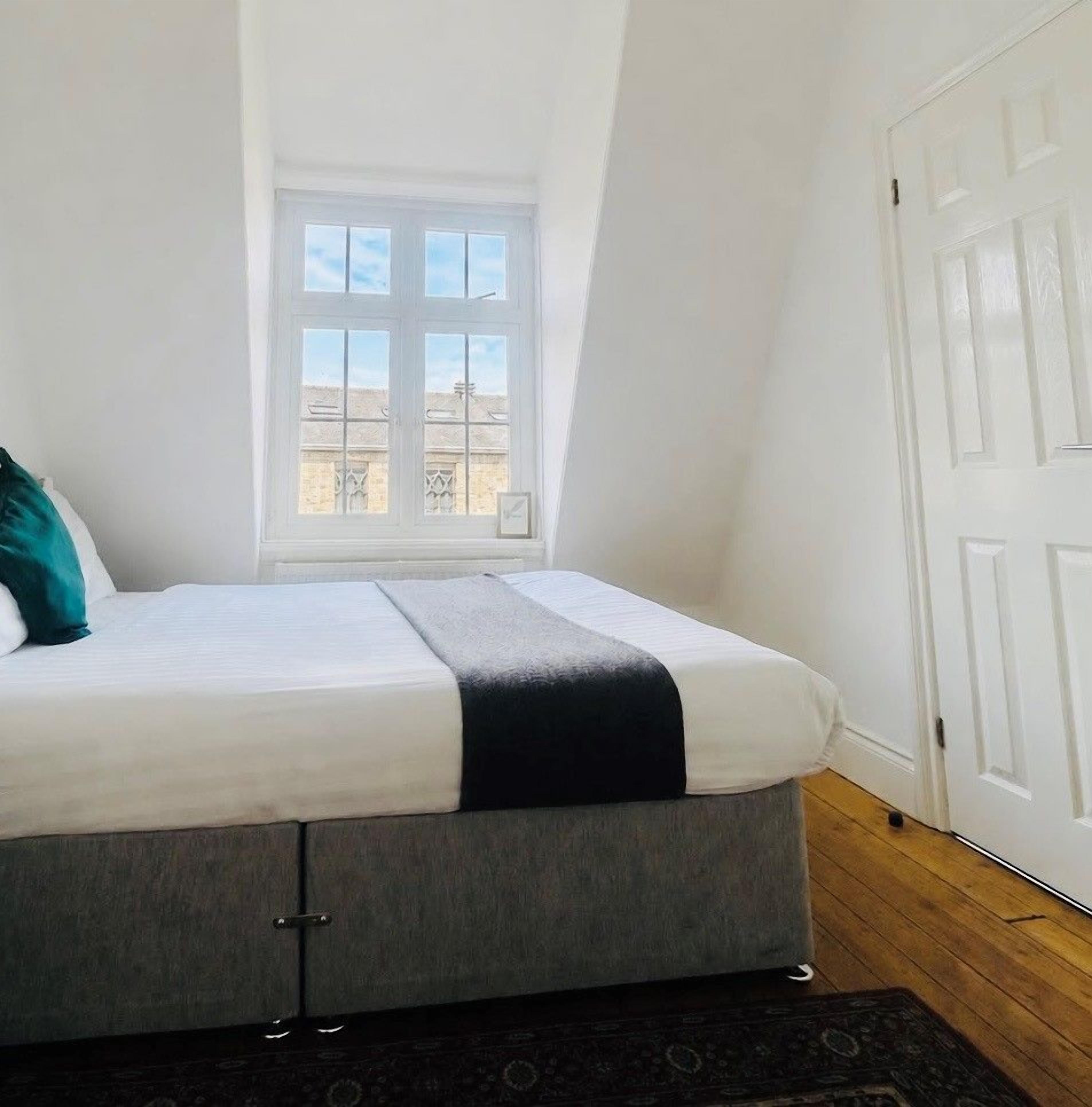 Une chambre à coucher avec un lit, une fenêtre et une porte.