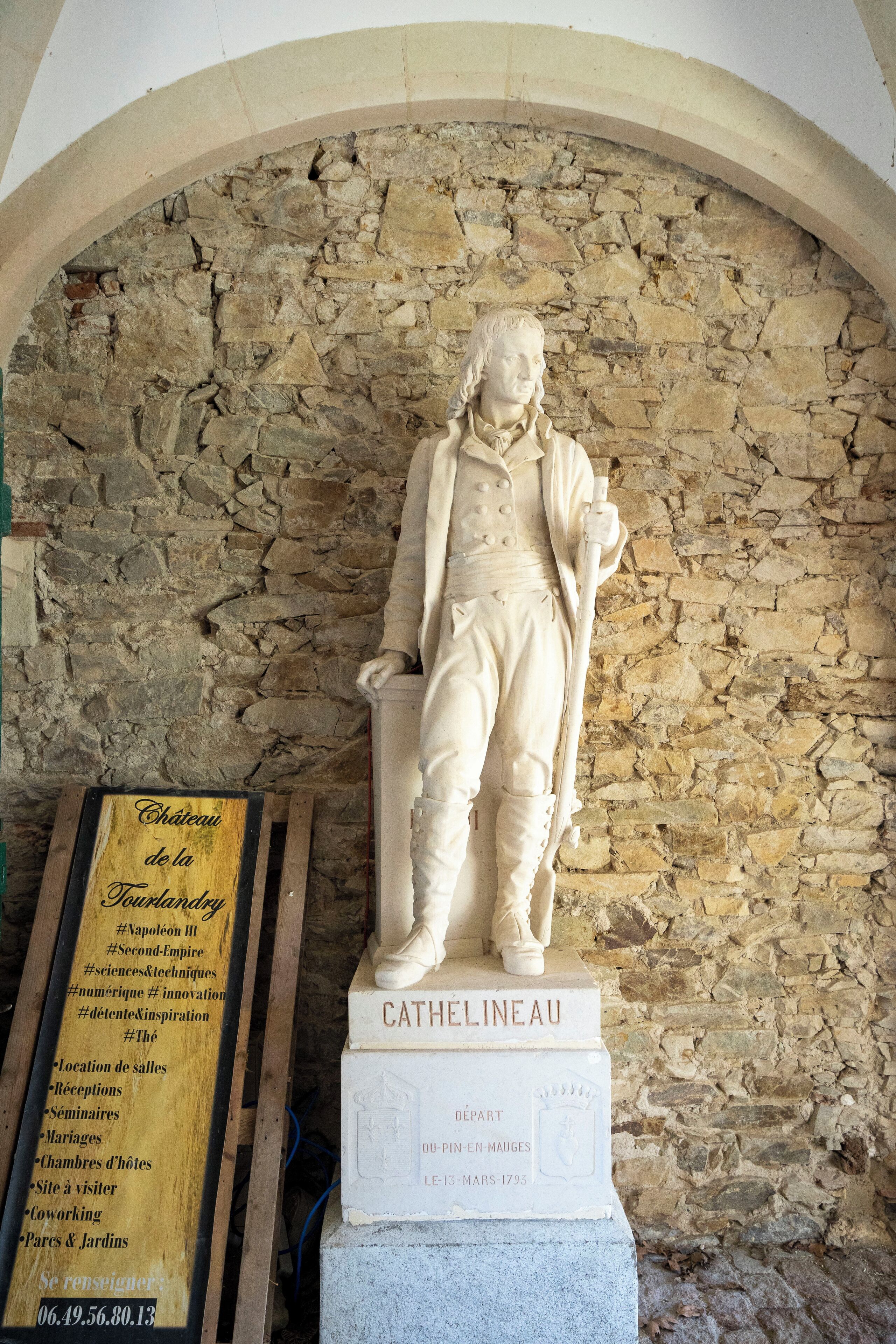En statue af en historisk person med en plade, hvor der står "CATHELINEAU", og et skilt, der viser forskellige begivenheder og steder.