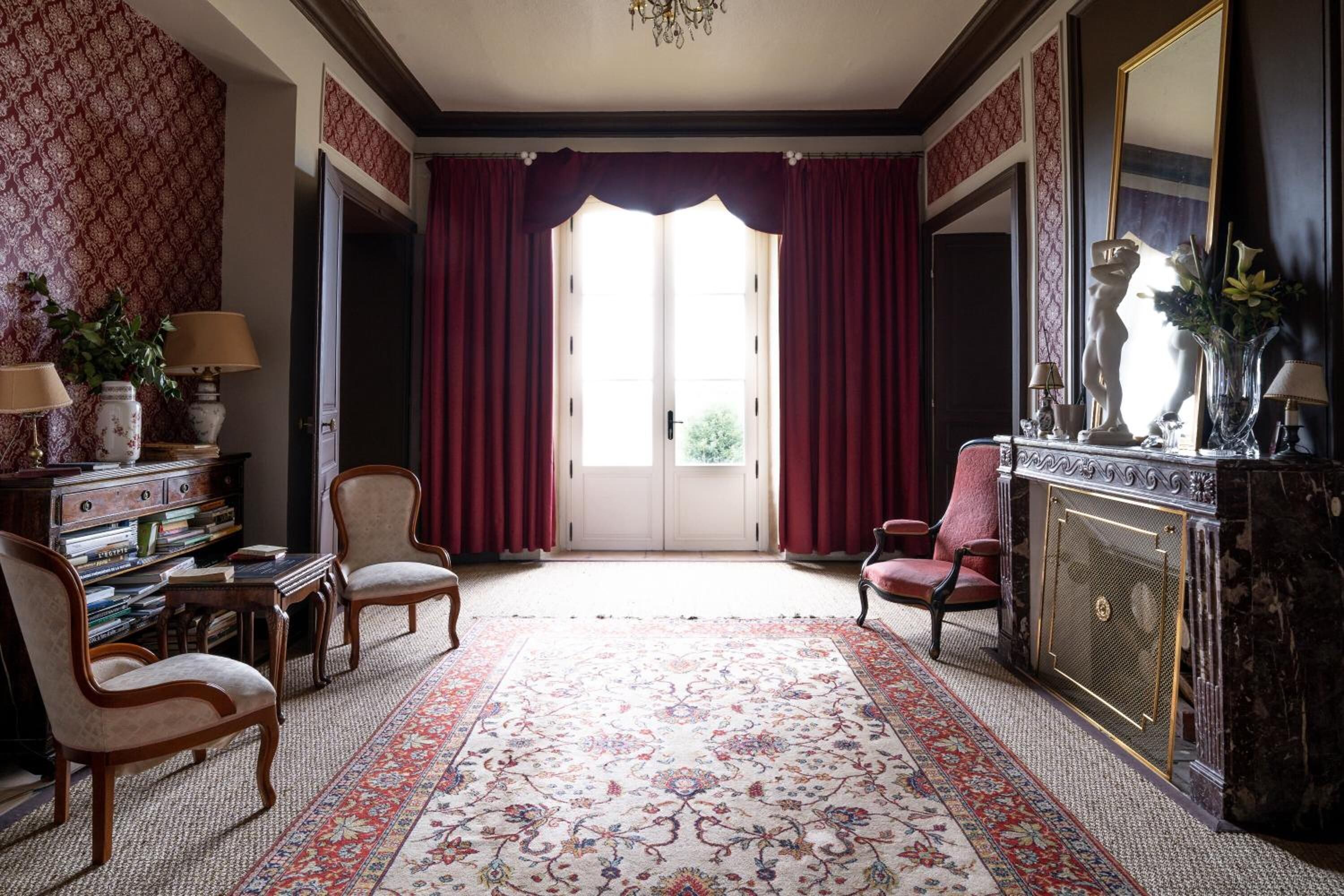 Une pièce dotée d’une grande fenêtre, d’une cheminée et d’un décor de style classique.