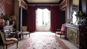 Une pièce dotée d’une grande fenêtre, d’une cheminée et d’un décor de style classique.