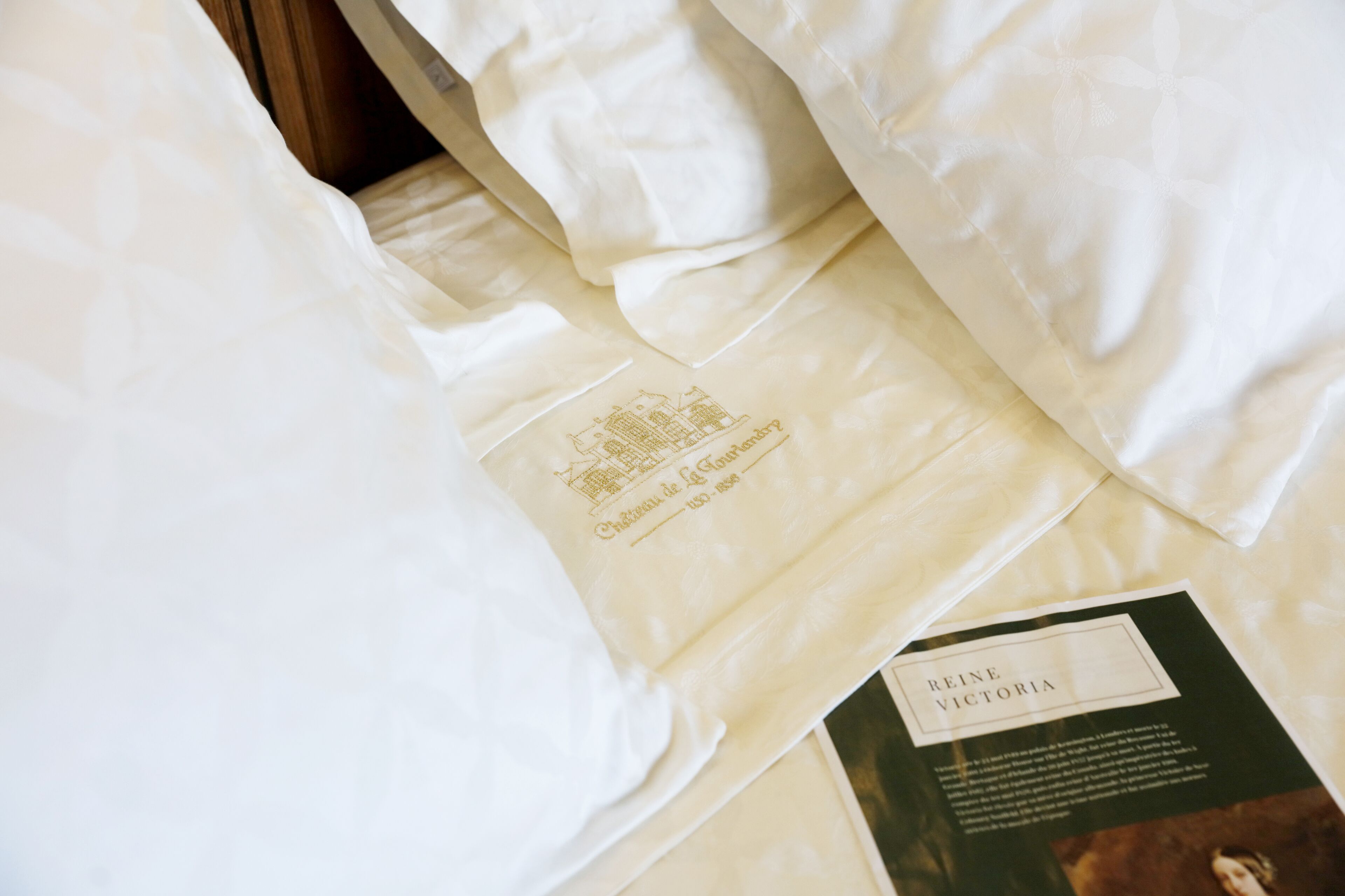 Una cama bien hecha con una etiqueta visible y un folleto.