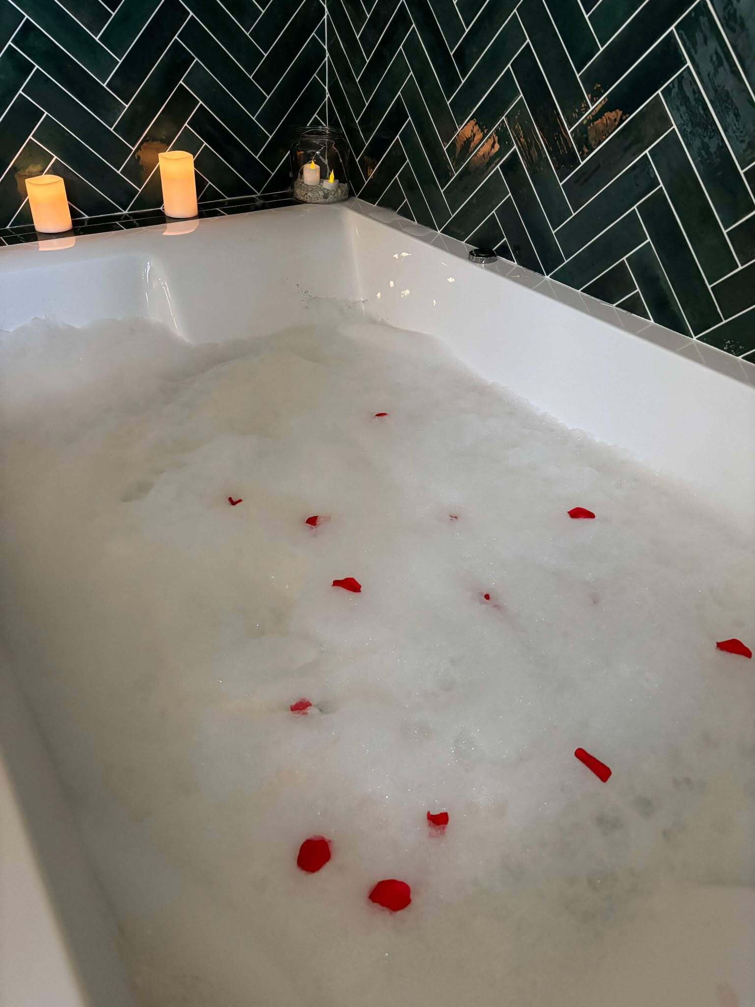 Uma banheira cheia de bolhas e pétalas de rosa.