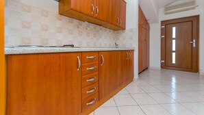Une cuisine avec des meubles en bois, un plan de travail et un pare-feu en carrelage.
