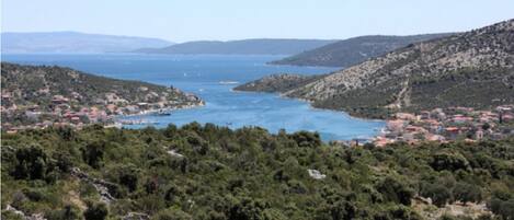 Un pueblo costero con abundante vegetación y un mar azul cristalino.