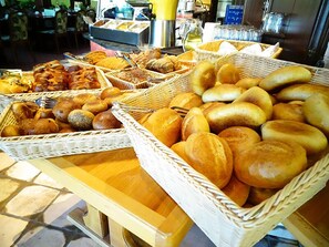 Une table de buffet proposant une variété de pains et de viennoiseries.
