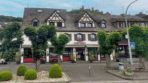 Un bâtiment traditionnel avec une enseigne indiquant « DORMERO » et l’entrée d’un hôtel.