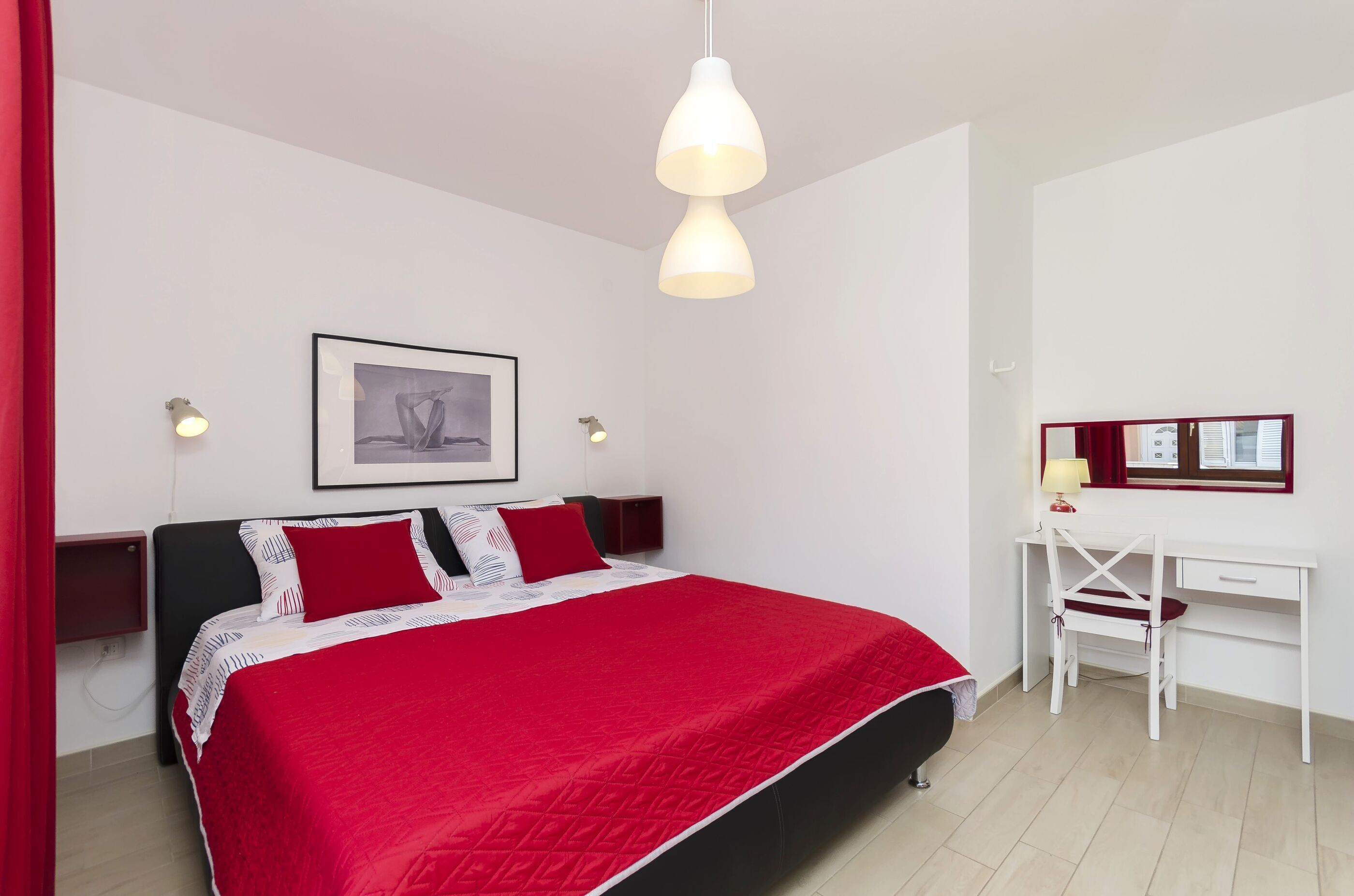 Ein Schlafzimmer mit Bett, Schreibtisch und Stuhl.