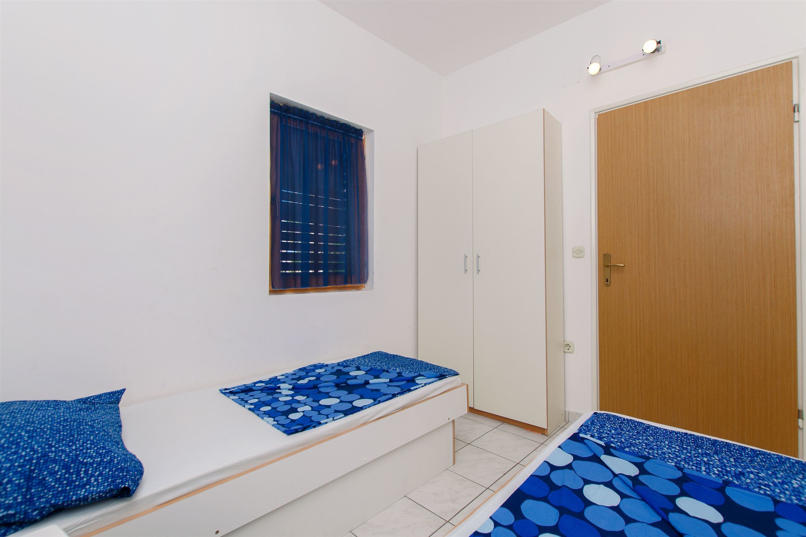 Un dormitorio con cama, armario y puerta.