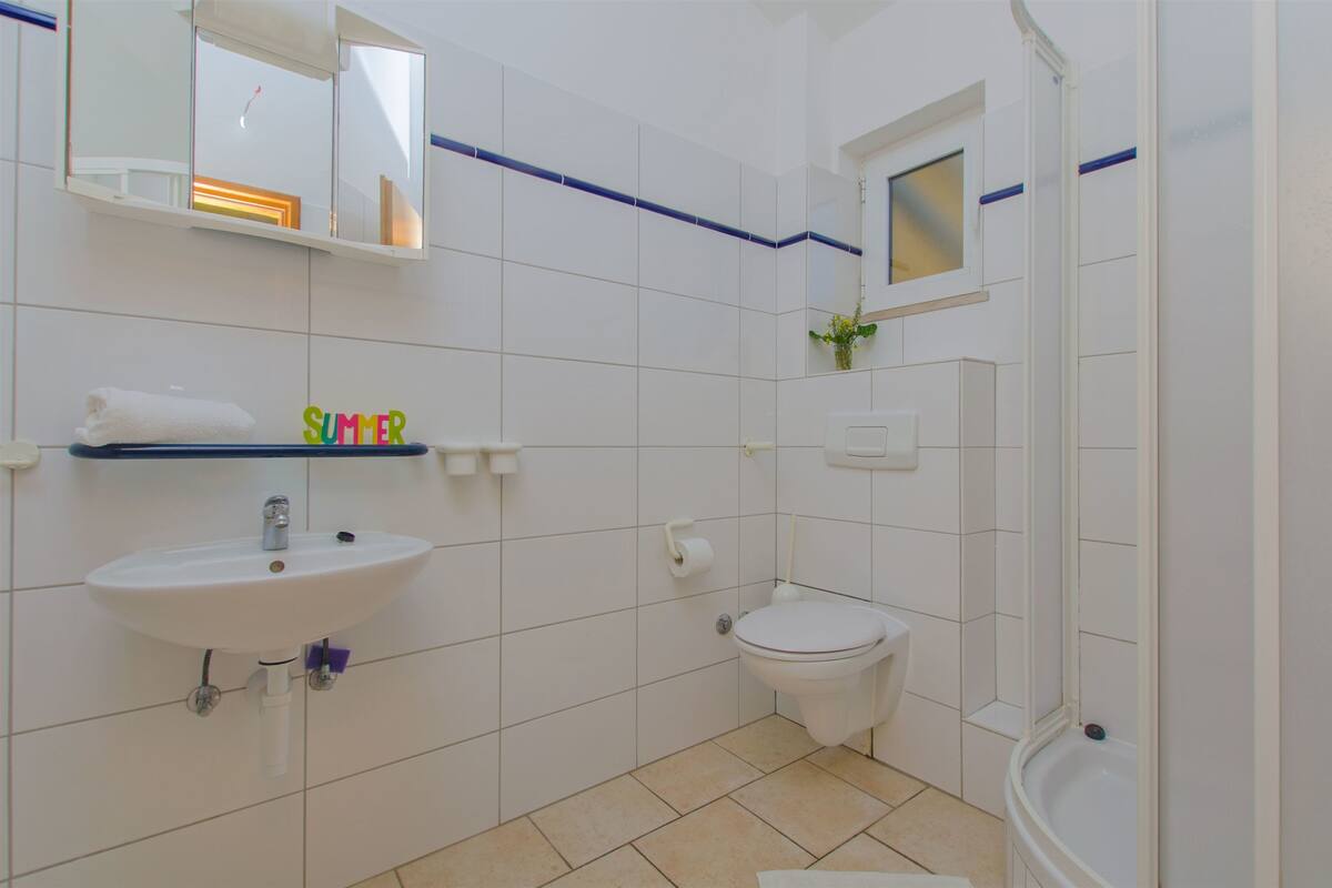 A bathroom with a sink, toilet, and shower.