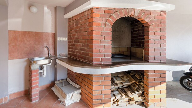 A brick-built outdoor oven with a sink and firewood storage. - Apartment Albina (Palit)
