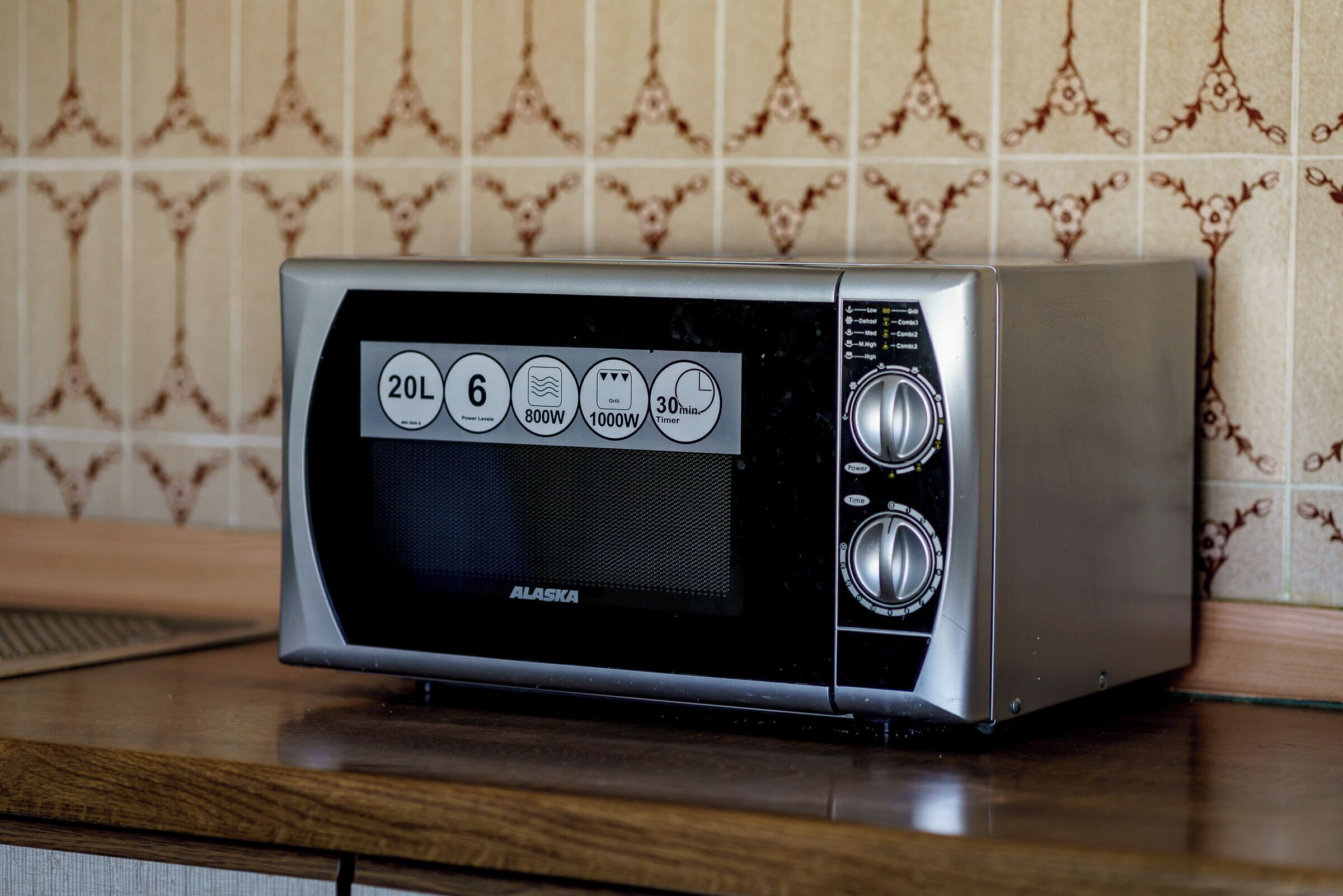 Un horno microondas compacto con pantalla digital, temporizador y botón de encendido.