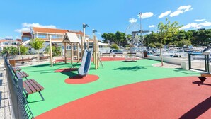 A playground with a slide, benches, and a Ferris wheel in the background. - Apartment Ines (Vodice)
