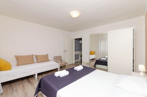 Une chambre d’hôtel avec deux lits simples, une chaise, un miroir et une table de chevet avec une lampe.