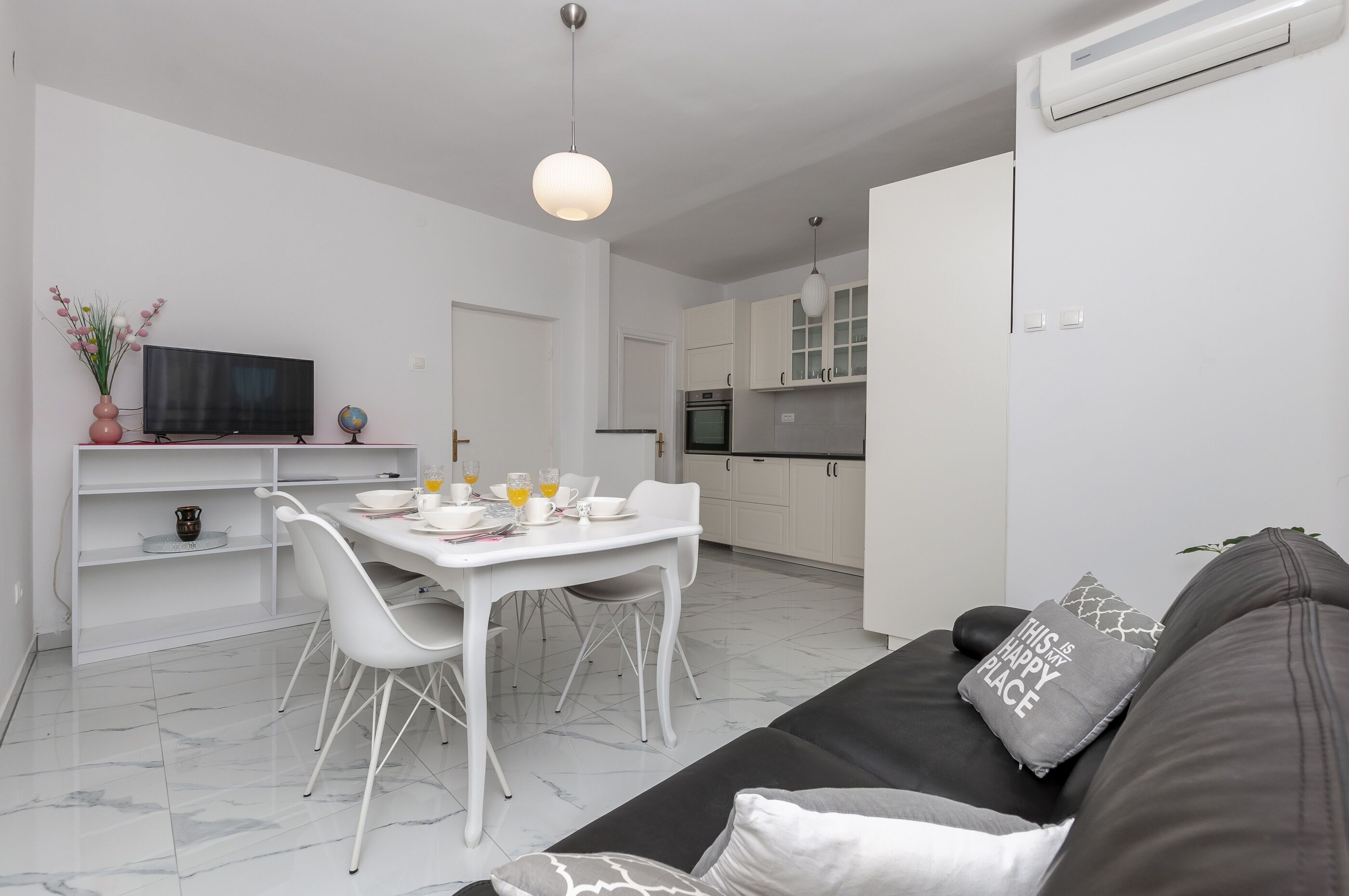 A modern living space with a dining area, kitchen, and seating area.