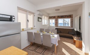 A compact kitchen with a dining area, a sofa, and a view of the outdoors.