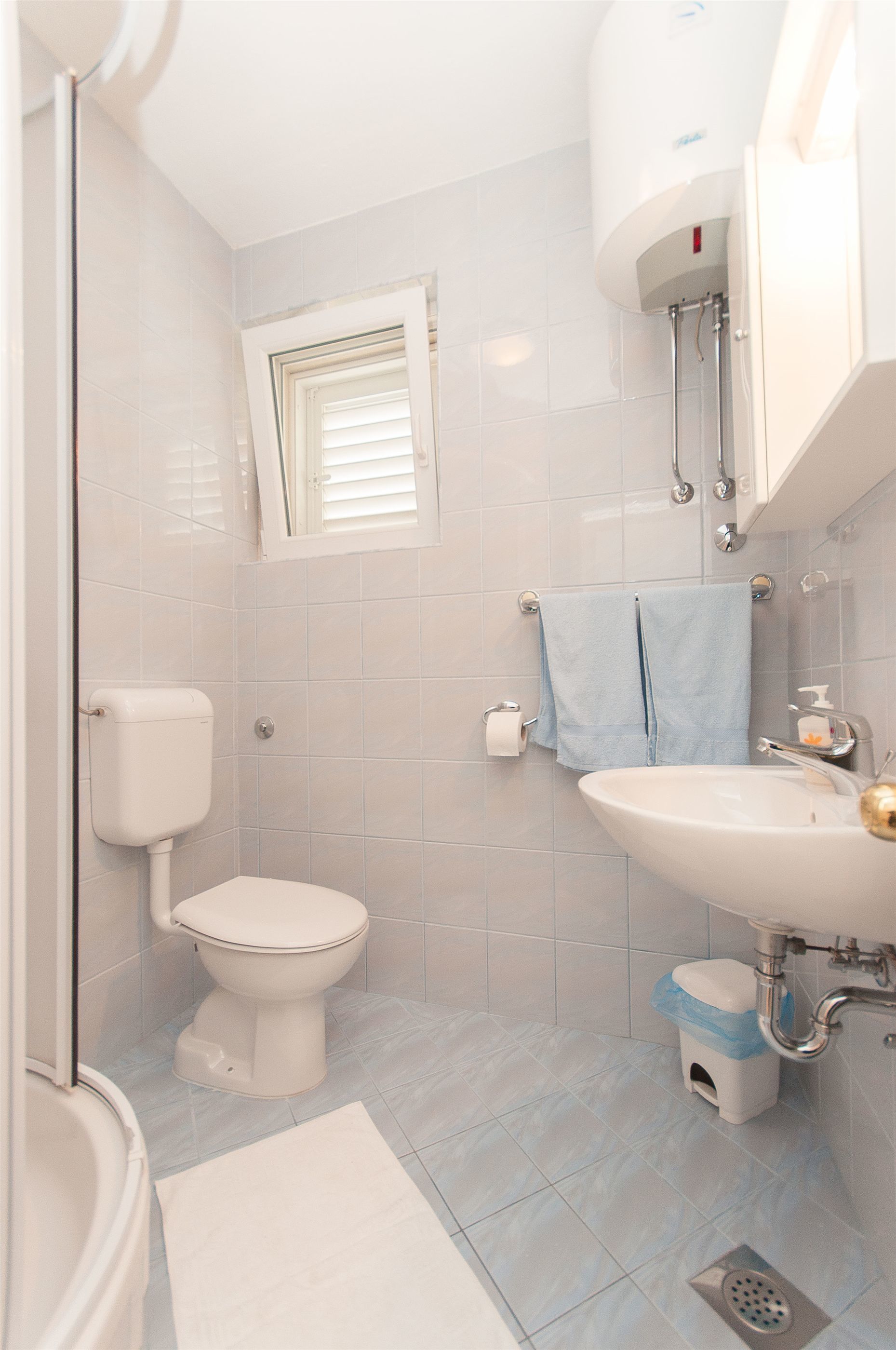 Une salle de bain avec des toilettes, un lavabo et une douche.