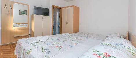 Un dormitorio con cama, armario y espejo.