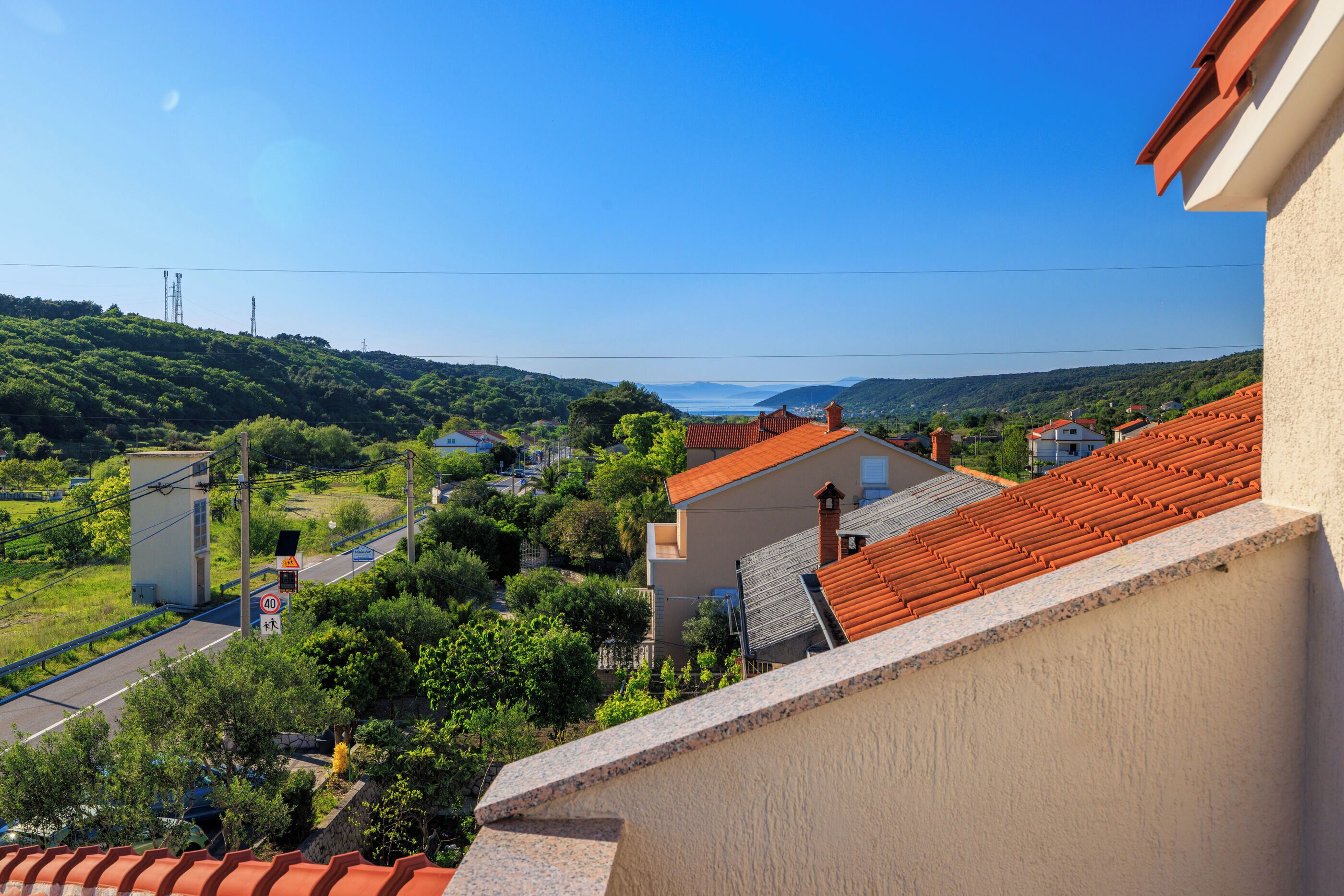 Ein Wohngebiet mit Häusern, einer Straße und freiem Blick auf das Meer.