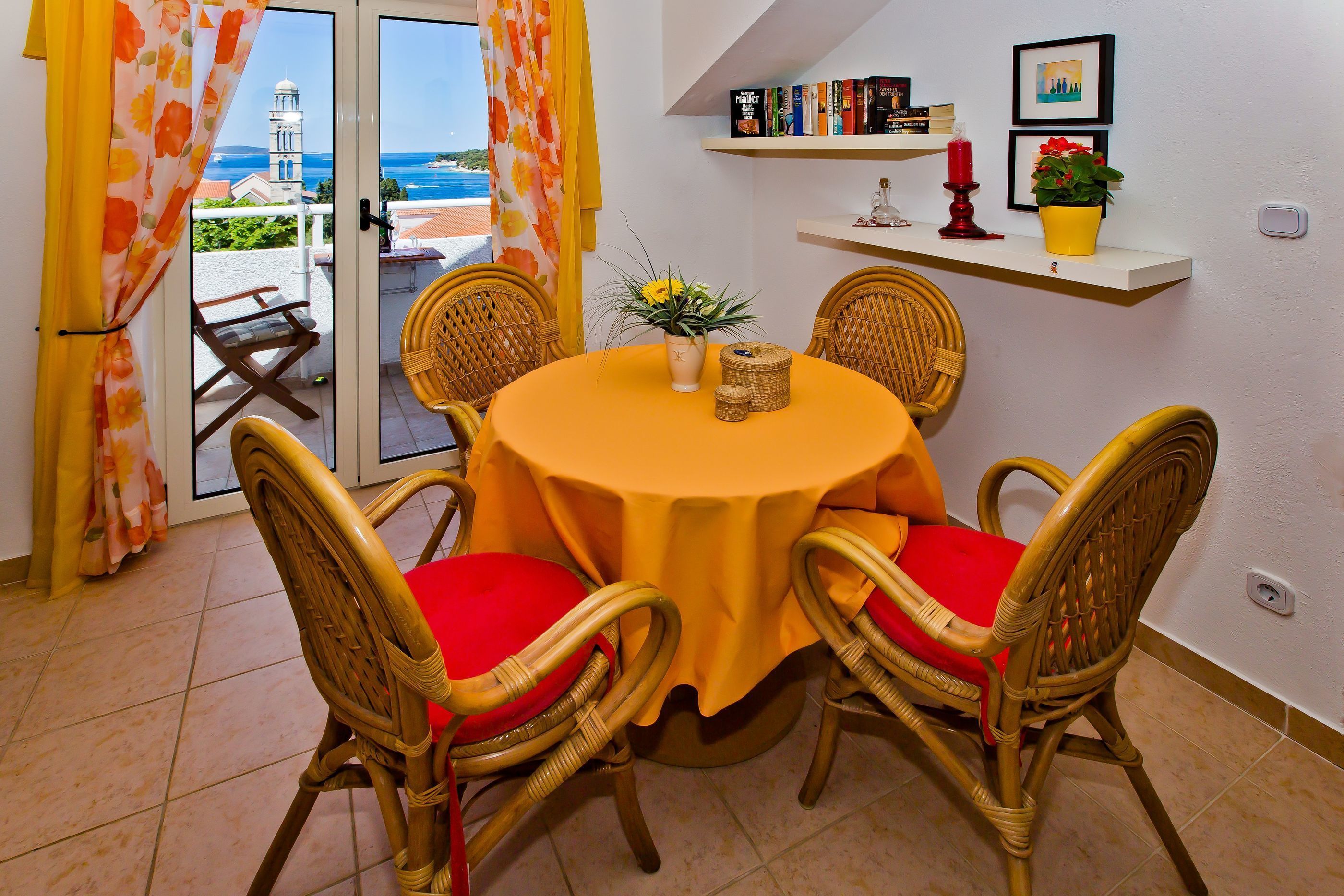 A dining area with wicker chairs and a table covered with a yellow tablecloth.