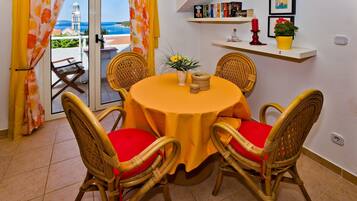 A dining area with wicker chairs and a table covered with a yellow tablecloth.