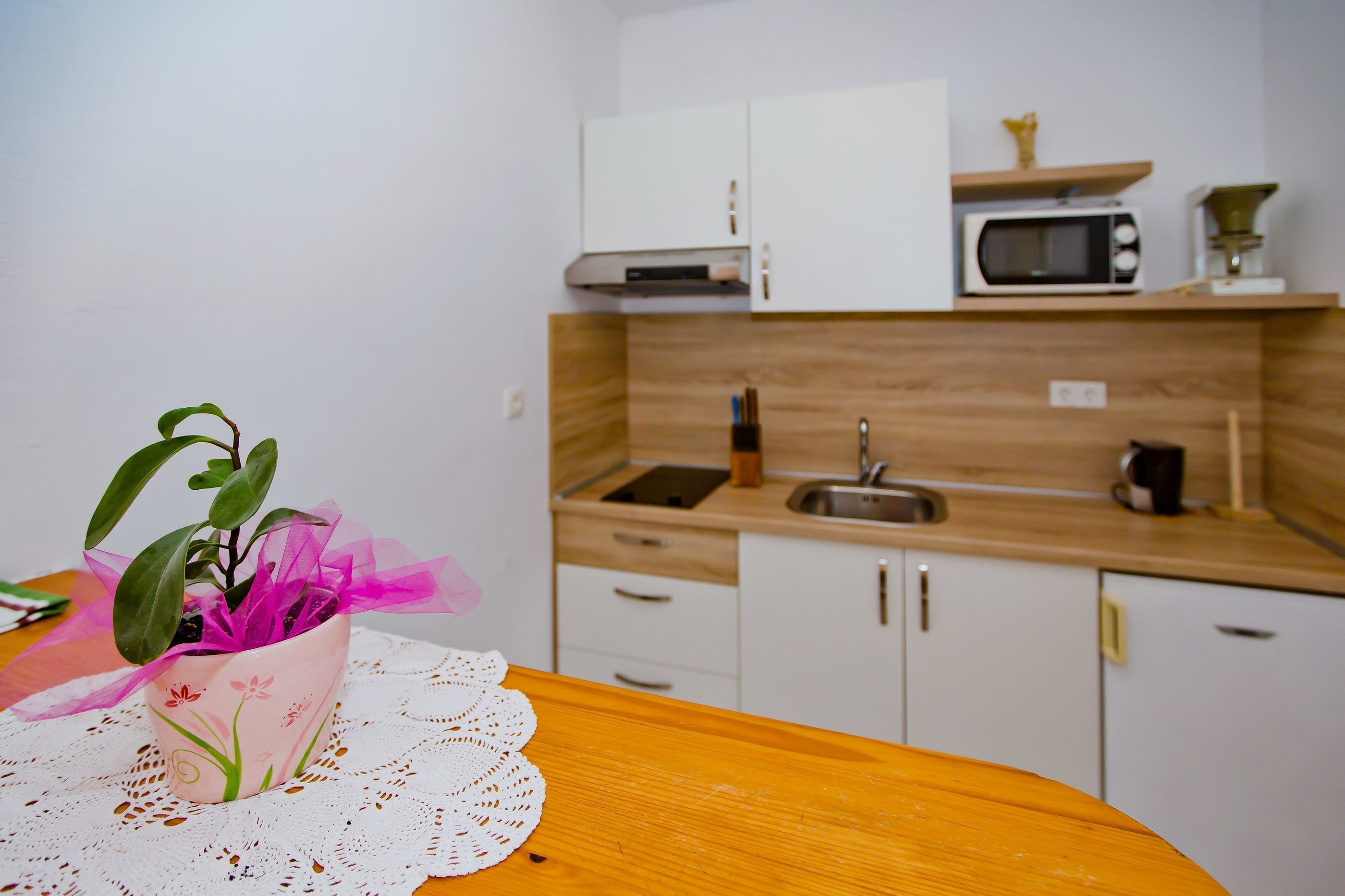 A kitchen with white cabinets, a microwave, and a sink.