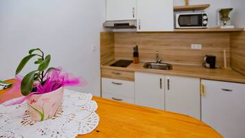 A kitchen with white cabinets, a microwave, and a sink.