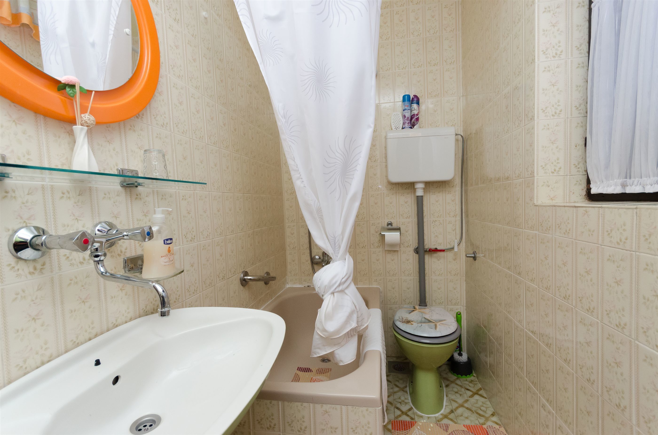 Un baño con lavabo, inodoro y cortina de ducha.