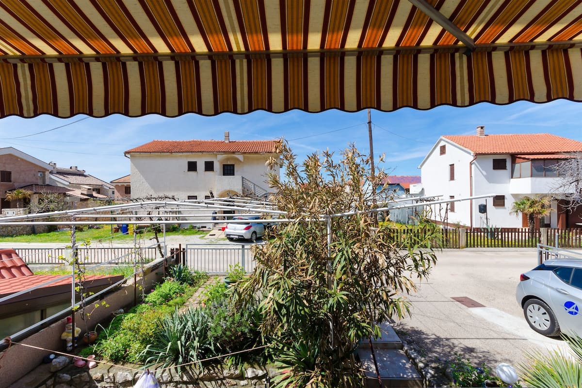 A residential area with houses, a covered outdoor area, and a street.