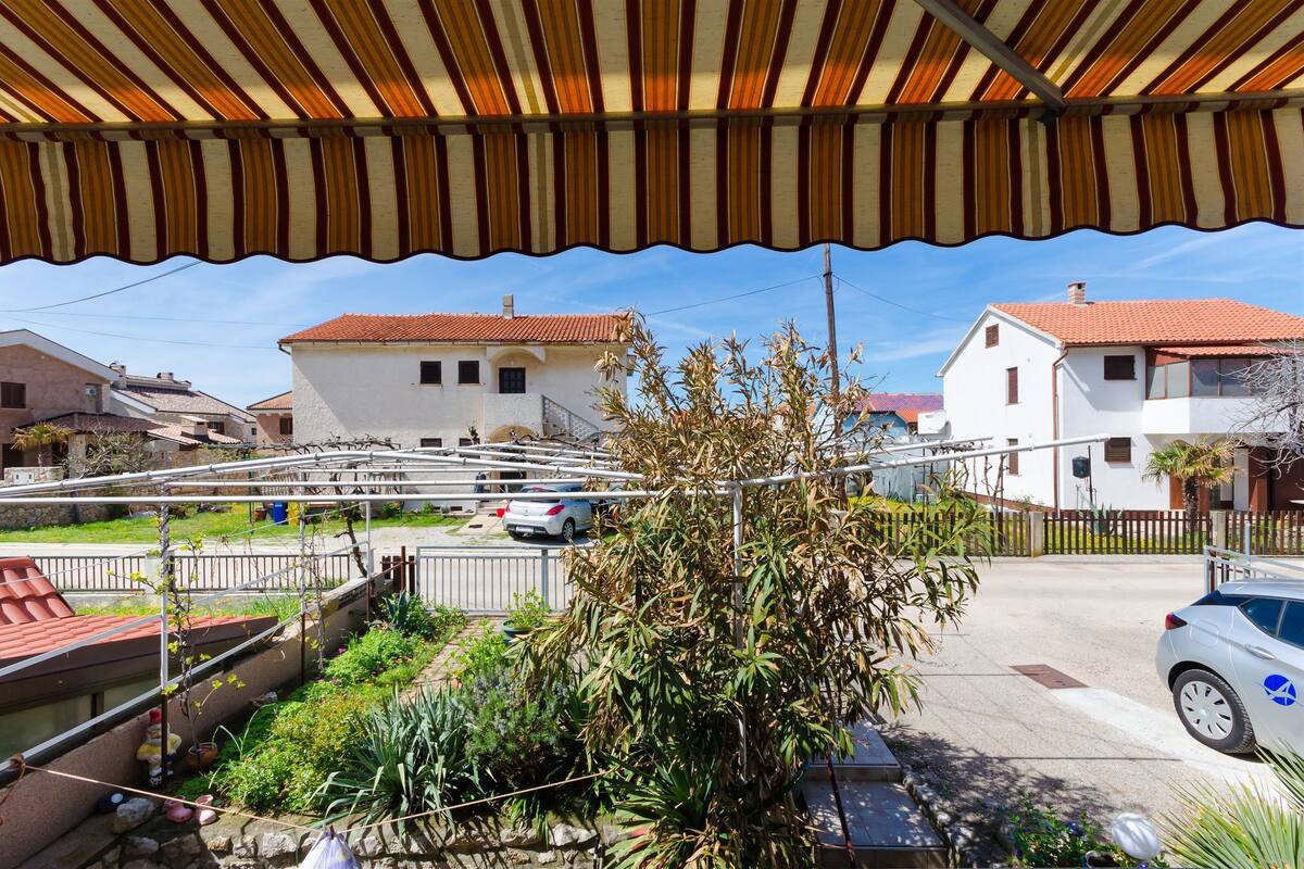 A residential area with houses, a covered outdoor area, and a street.