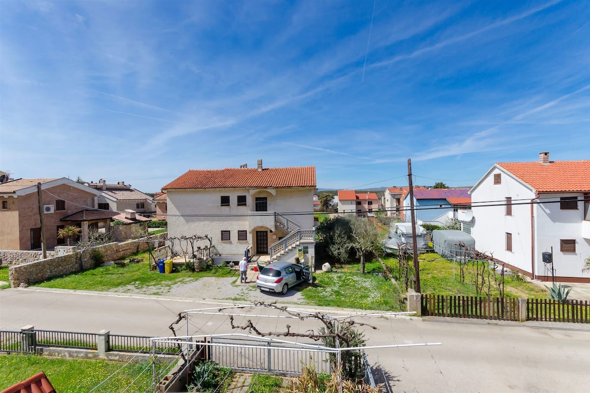 A residential area with houses, a street, and a parked car.