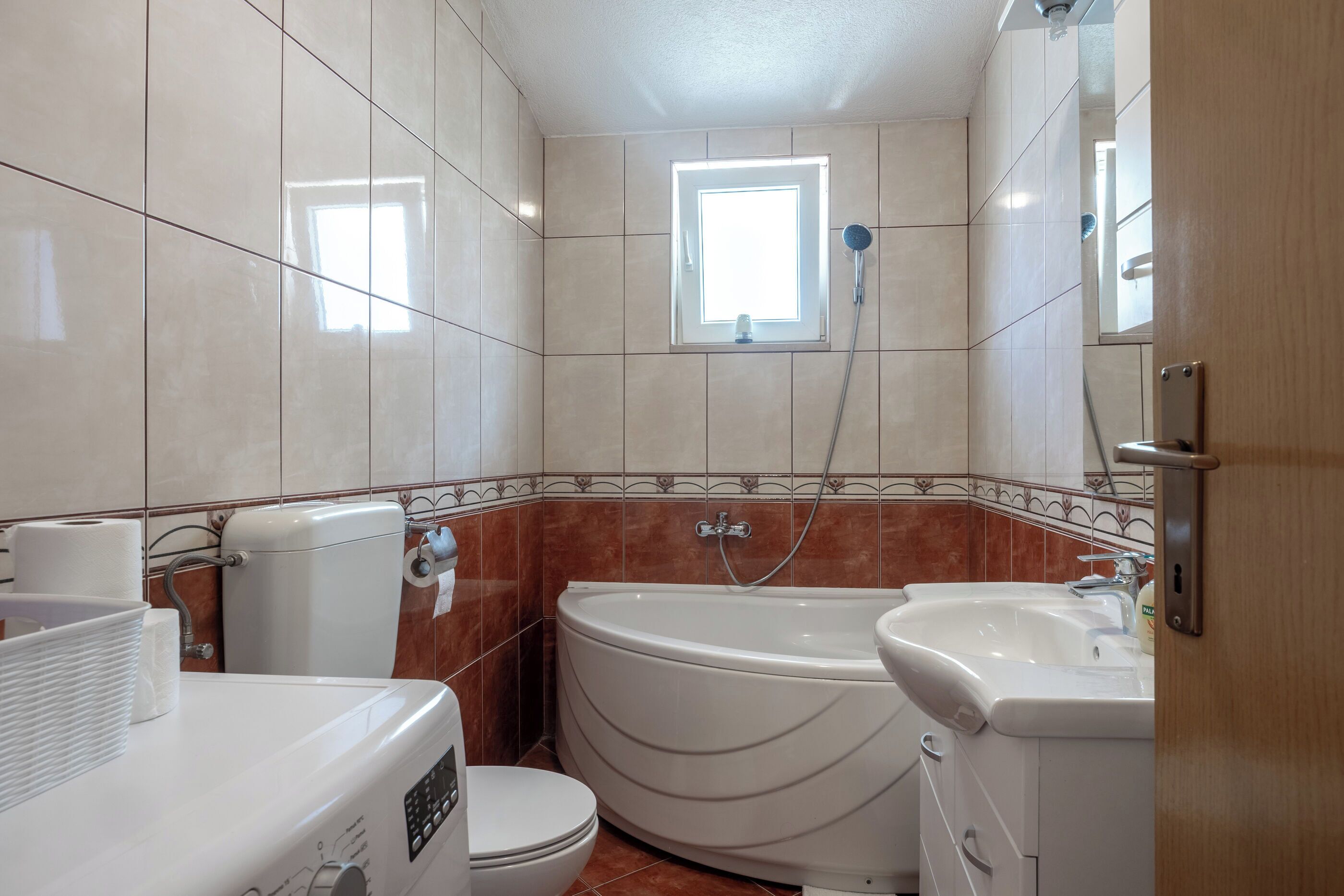 Une salle de bain avec des toilettes, un lavabo et une baignoire.