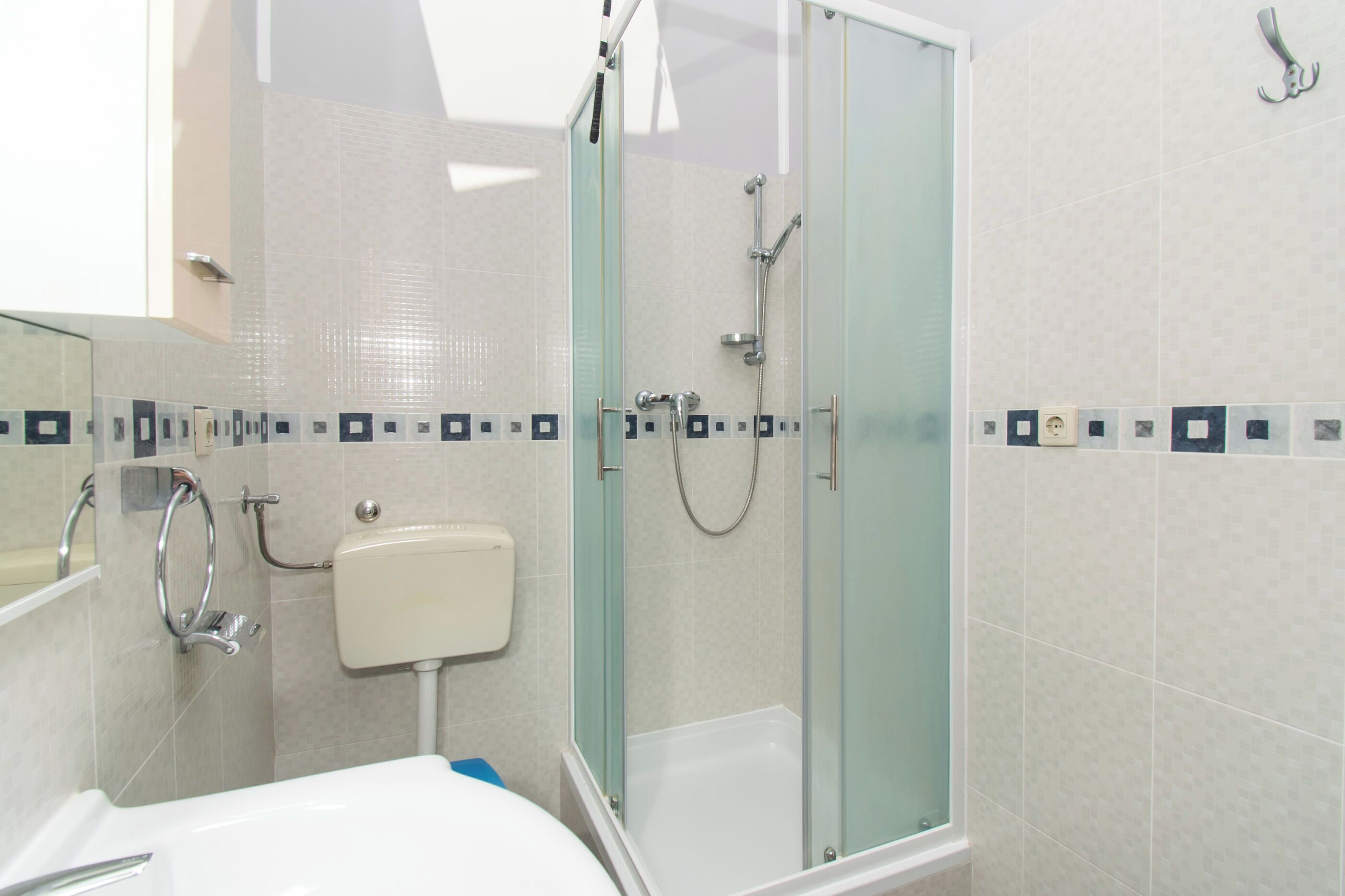 Un baño moderno con ducha de vidrio, inodoro y lavamanos.