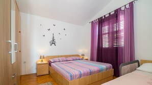 Un dormitorio con una cama de madera, una mesita de noche, un escritorio y una silla.