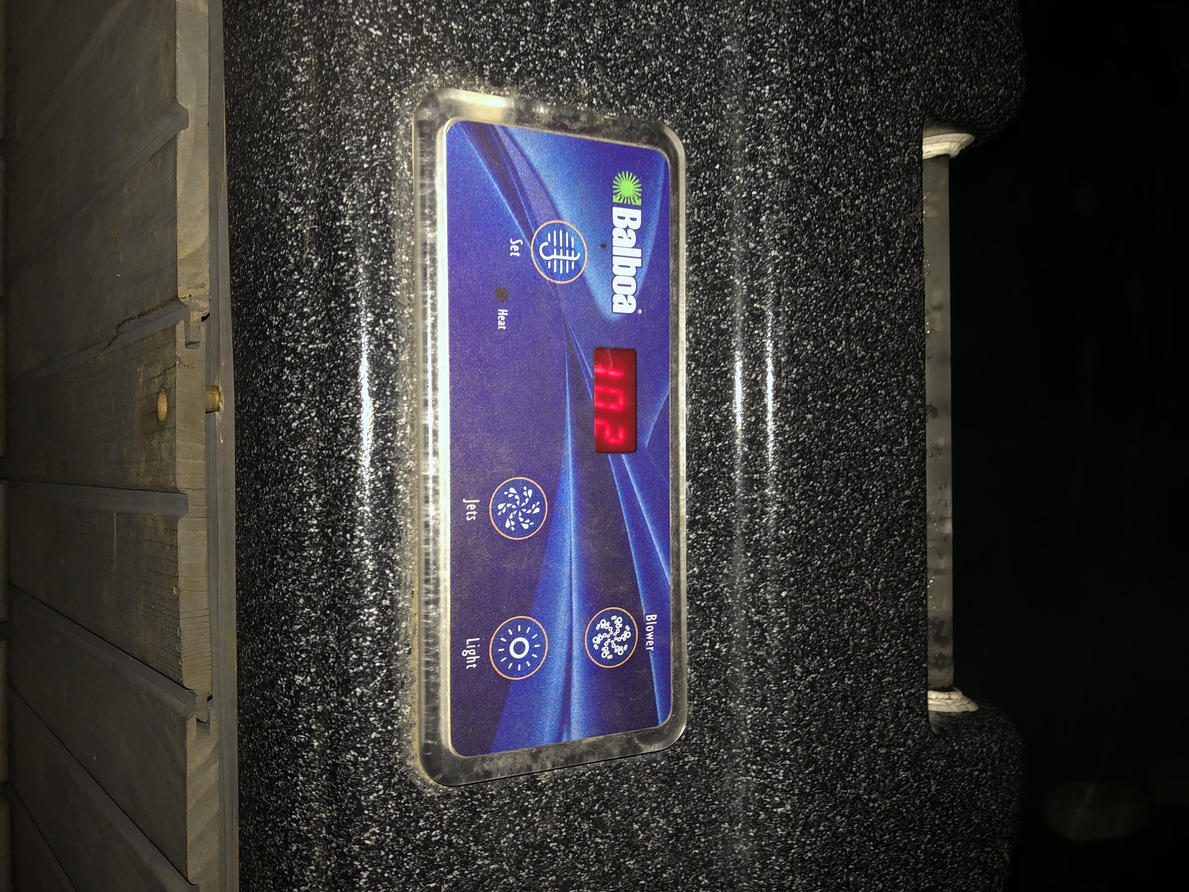 A thermostat with a digital display indicating 10.2 degrees Celsius, set to heat, and a light switch.