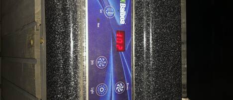 A thermostat with a digital display indicating 10.2 degrees Celsius, set to heat, and a light switch.