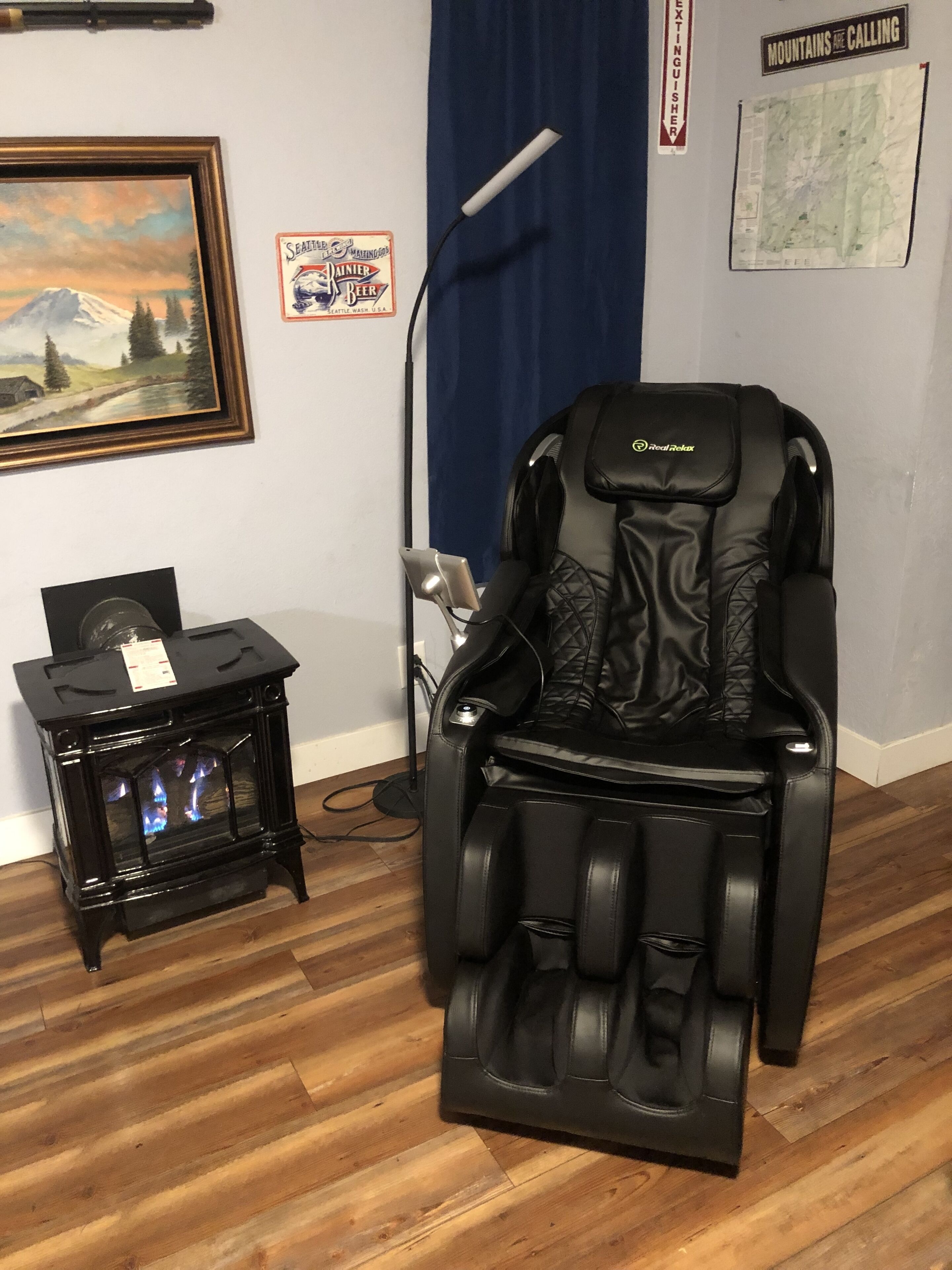 Un fauteuil massant, un petit radiateur et un tableau accroché au mur.