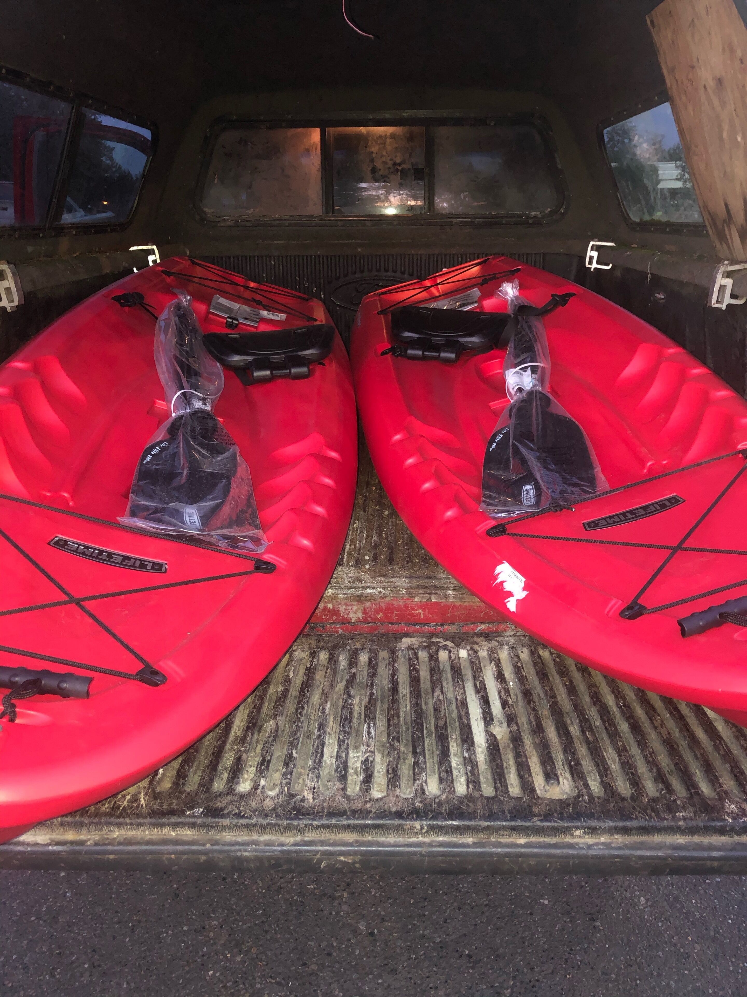 Interior de un vehículo con dos kayaks en la parte trasera.