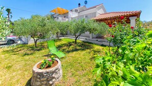 A residential property with a garden, a pergola, and a red-tiled roof. - Apartments Damir - Katarina (Sutivan)