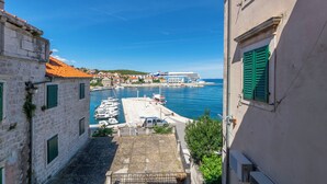 A narrow street with a view of a marina and boats. - Apartment Ljerka (Postira)