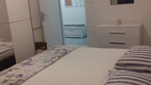 Un dormitorio con cama, cómoda, espejo y puerta que da al baño.