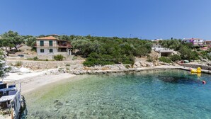 A coastal property with a clear pool, stone walls, and a view of the sea. - Apartments Davorka (Gdinj)