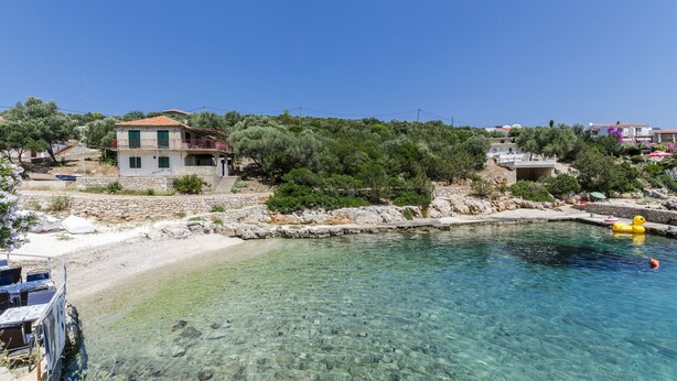 A coastal property with a clear pool, stone walls, and a view of the sea. - Apartments Davorka (Gdinj)