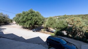 A residential street with parked cars, trees, and houses in the background. - Apartments Davorka (Gdinj)