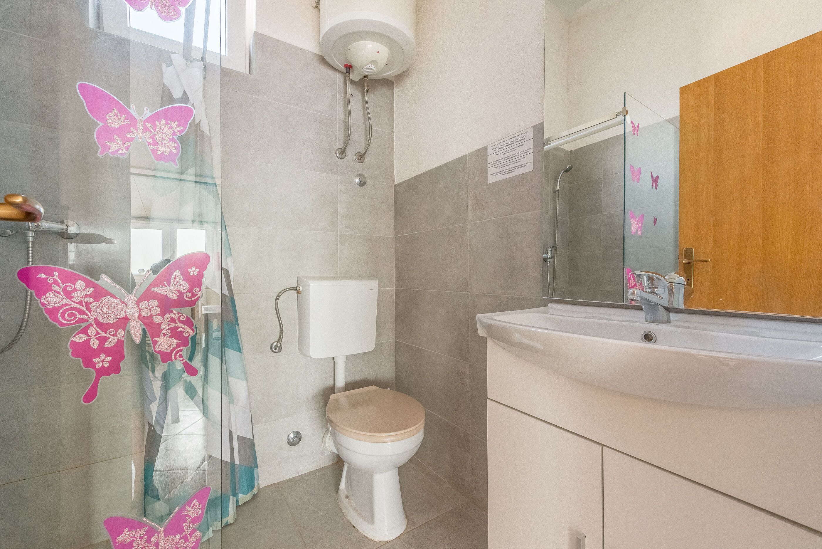 A bathroom with a toilet, sink, and shower.